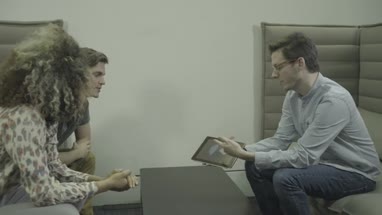 Man holding digital tablet and having discussion with business friends in office