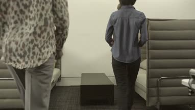 Men and women sitting together and having discussion with digital tablet in office