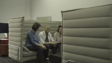 Men and women sitting together and having discussion with digital tablet in office