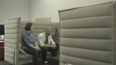 Men and women sitting together and having discussion with digital tablet in office