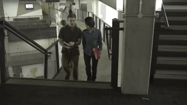Man and woman holding diary and having discussion while walking in office lobby
