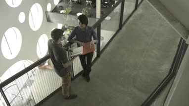 Man and woman holding diary and having discussion in office lobby