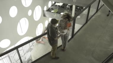 Man and woman talking each other in office lobby