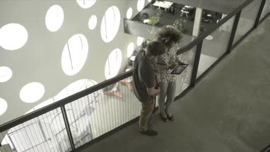 Man and woman using digital tablet in office lobby