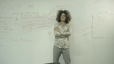 Young woman sticking adhesive note on notice board in office