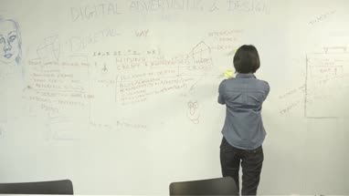 Woman sticking adhesive note on notice board in office