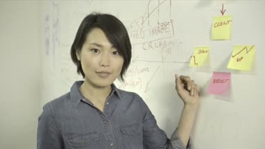 Woman sticking adhesive note on notice board in office