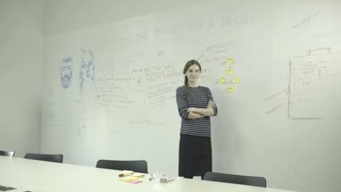 Young woman sticking adhesive note on notice board in office