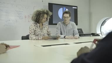 Men and women using digital tablet during meeting in conference room
