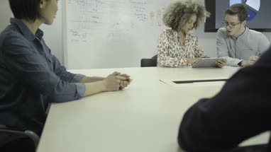 Men and women using digital tablet during meeting in conference room