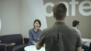 Man and woman enjoying coffee and talking in office café