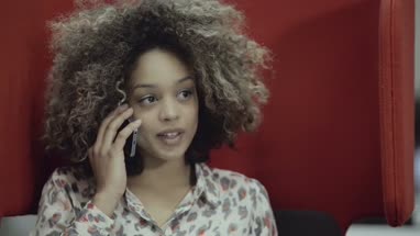 Young woman talking on mobile phone in office