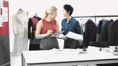 Fashion designer looking at designs in studio