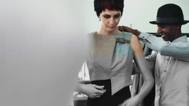 Fashion designer dressing mannequin fashion model in studio