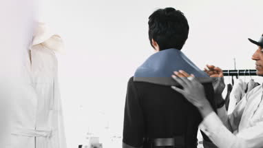 Fashion designer dressing mannequin fashion model in studio