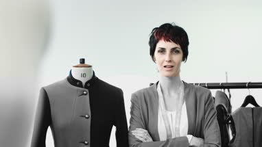 Fashion designer dressing mannequin fashion model in studio