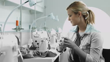 Fashion designer at sewing machine having a coffee break