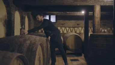 Farmer pouring wine from barrel