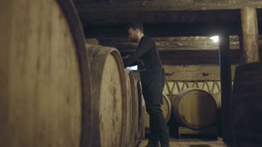 Farmer pouring wine from barrel