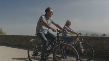 Senior couple cycling on electric bicycles