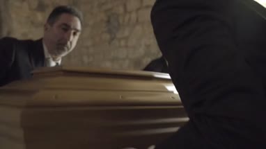 Pallbearers leaving Church with coffin followed by family