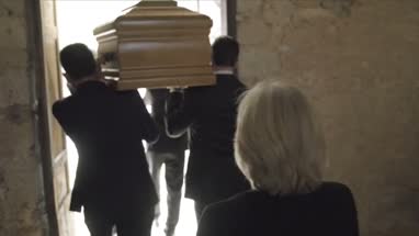 Pallbearers leaving Church with coffin followed by family