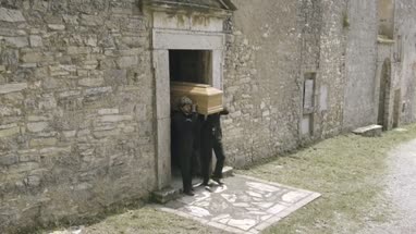 Pallbearers leaving Church with coffin followed by family
