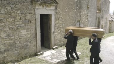 Pallbearers walking into church with coffin