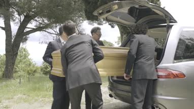 Pallbearers in Hearse arriving with coffin at graveyard