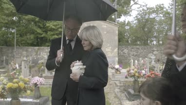 Mourners standing at funeral with cremation urn
