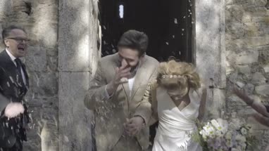 Family throwing confetti over bride and groom