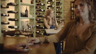 Young adult female waiting for someone at wine bar 