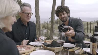 Parents with grown-up son dining outdoors