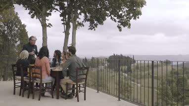 Senior giving speech to family at meal