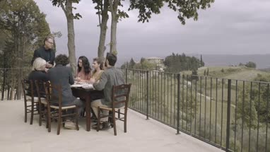 Senior giving speech to family at meal