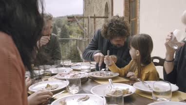 Father helping daughter at family meal