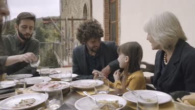 Granddaughter happily eating at family meal