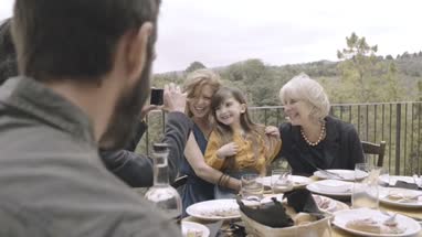 Father taking picture of family meal