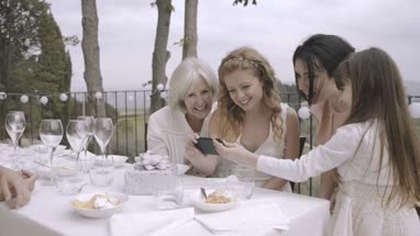 Bride and bridesmaids looking at photos
