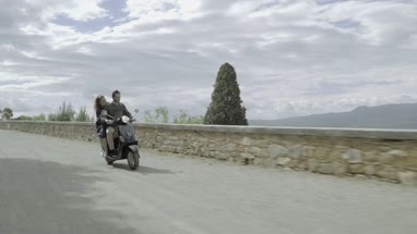 Young couple riding on scooter 