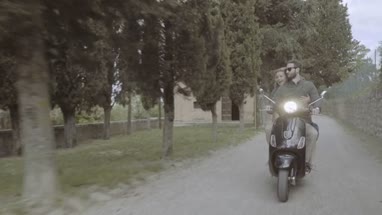 Young couple riding on scooter 