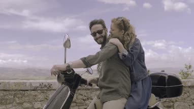 Young couple on scooter kissing