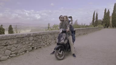 Couple on scooter taking selfie