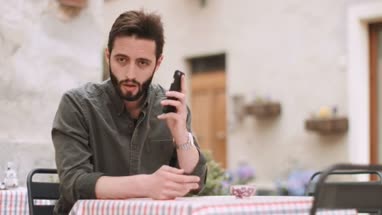 Young adult male using smart phone in cafe