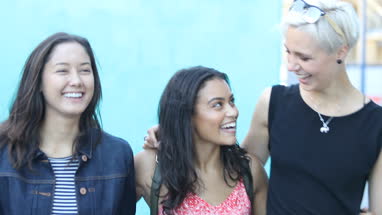 Young female friends walking down street