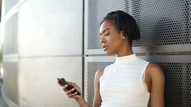 Afro american using smartphone outdoors