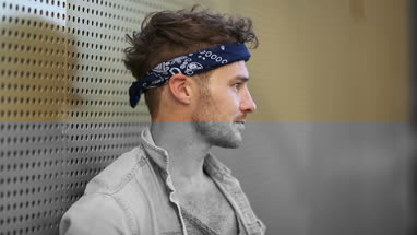 Portrait trendy male leaning on wall