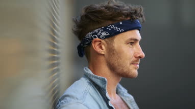 Portrait trendy male leaning on wall