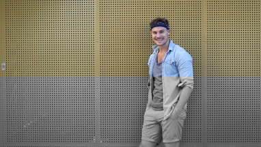 Portrait trendy male leaning on wall