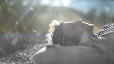 Trendy male sunbathing in long grass